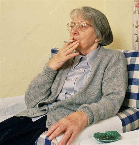 Elderly woman smoking a cigarette - Stock Image - M370/0442 - Science Photo Library