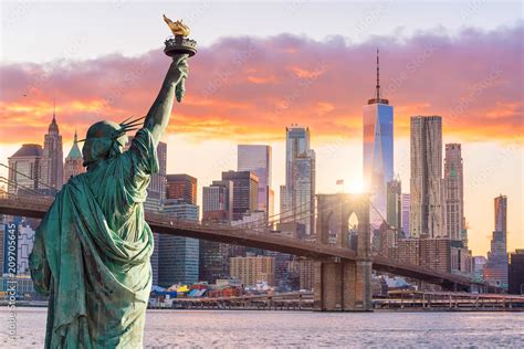 Statue Liberty and New York city skyline at sunset Stock Photo | Adobe Stock
