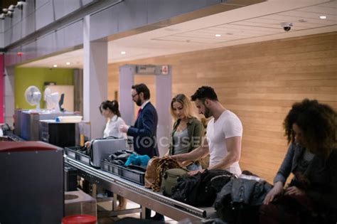 Commuters taking their baggage from baggage carousel at airport — male ...