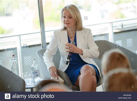 a woman sitting in a chair talking to other people