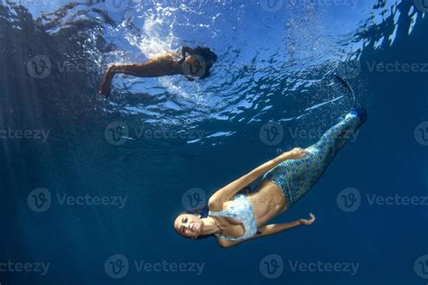 Mermaid swimming underwater in the deep blue sea 20383743 Stock Photo ...