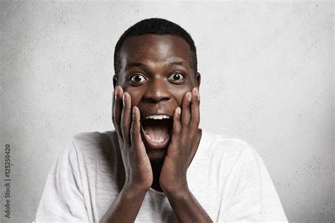 African employee or customer with shocked and surprised face, looking ...