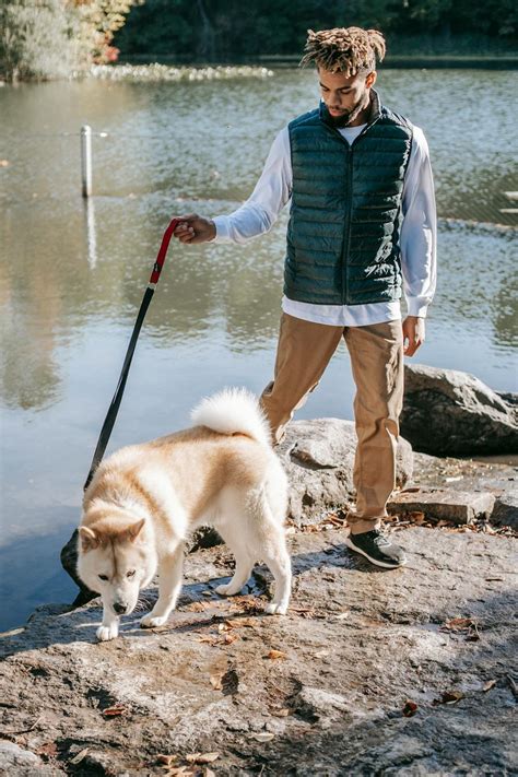 Black man walking with dog near lake · Free Stock Photo