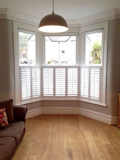Provide privacy with wooden shutters installed in the bottom half of the sash windows in aVictor ...