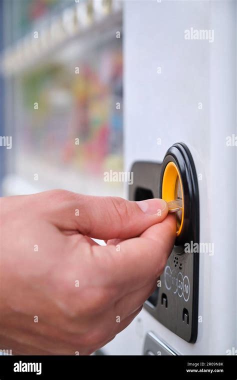 Hand paying 100 yen to get a drink in a japanese vending machine ...