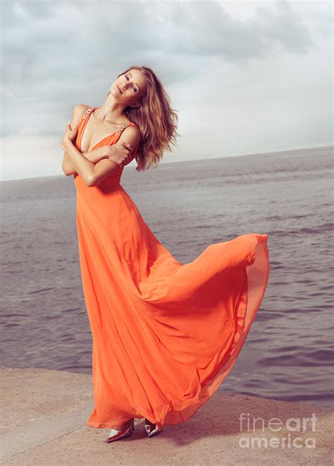 Young Woman In Orange Dress Flying In The Wind At Sea Shore Photograph ...