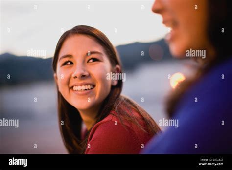 Girl smiling at friend Stock Photo - Alamy