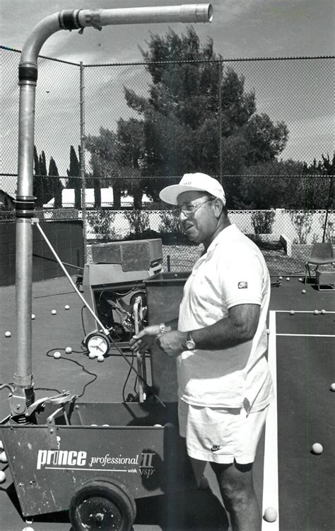 Mike Agassi, the father of Andre Agassi, loads and adjusts the ball ...