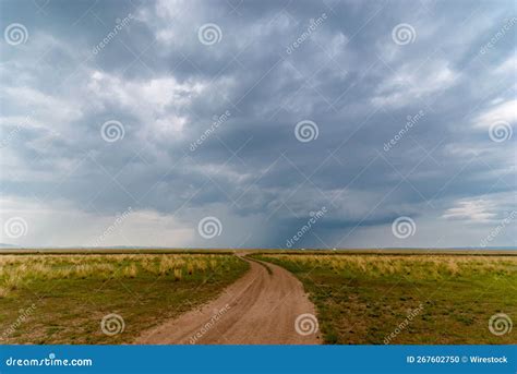 Landscape View of a Dirt Path between Green Meadows Under a Dramatic ...