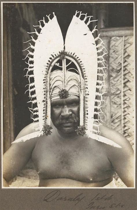 an old black and white photo of a man wearing a headdress