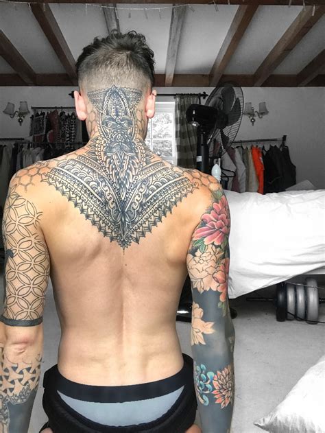 a man with lots of tattoos on his back