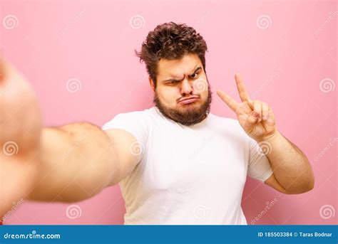 Funny Fat Man with Beard Takes Selfie on Pink Background and Shows Funny Face. Charismatic Young ...