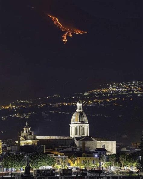 a city at night with lights on the buildings and trees in the ...