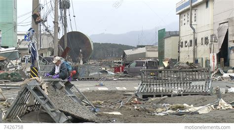 Japan Tsunami Aftermath - Man Walks Through Destroyed Port Stock video footage | 7426758