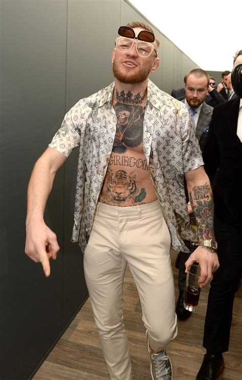 Conor McGregor at the Grand National in open-shirted white outfit ...
