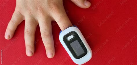 Pulse oximeter on child finger to measure pulse rate and oxygen levels ...