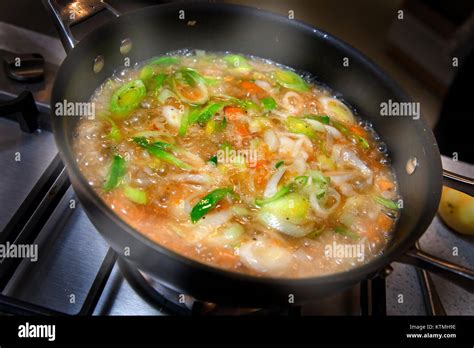 Vegetable soup simmering in pan on hob Stock Photo - Alamy