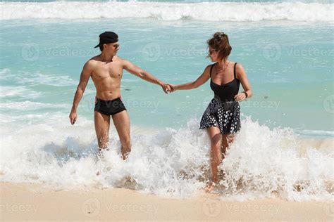 Young couple holding hands on the beach 16113097 Stock Photo at Vecteezy