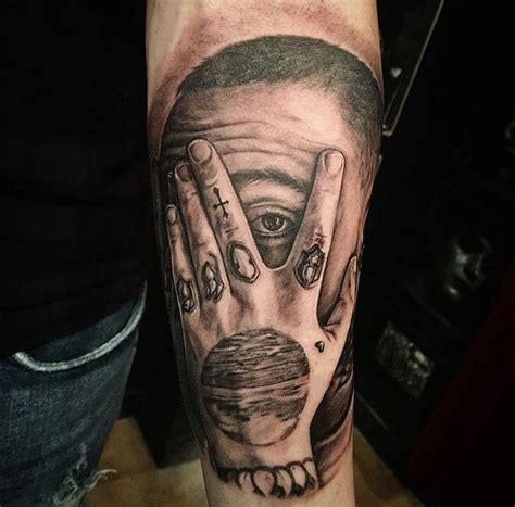 a man's arm with a tattoo on it that has two hands and an eye in the middle