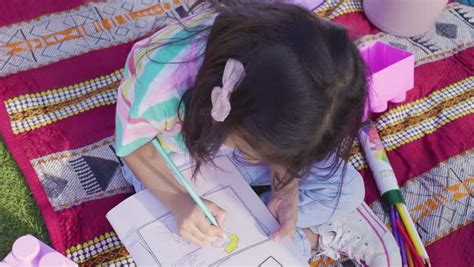 A Saudi girl doing drawing and coloring activities, a Saudi Gulf Arab family spending fun times ...