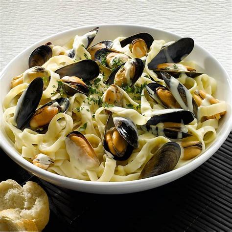 Mussels with creamy white wine sauce, served on a bed of tagliatelle | Mussels recipe white wine ...