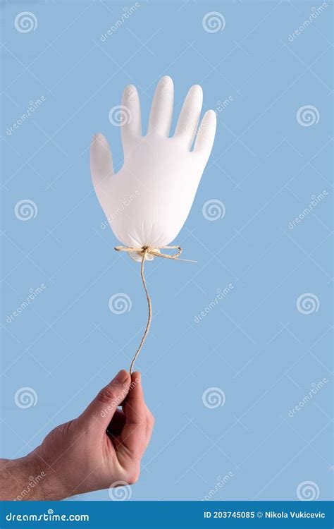 Hand holding glove balloon stock image. Image of care - 203745085