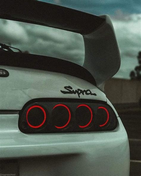 the rear end of a white sports car with red lights on it's taillights