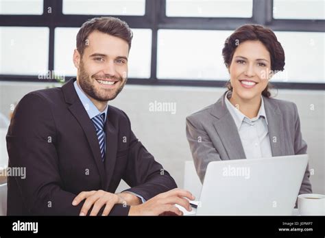 Happy business people with laptop in office Stock Photo - Alamy