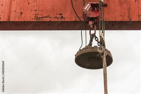 Magnet on a crane moving scrap metal. Industrial magnet. Crane magnet ...