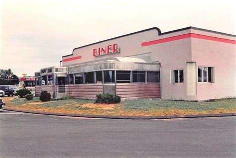 an old diner with cars parked in front of it