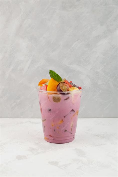 Premium Photo | Fruit cocktail with yogurt in disposable plastic take away cup es campur or sop buah