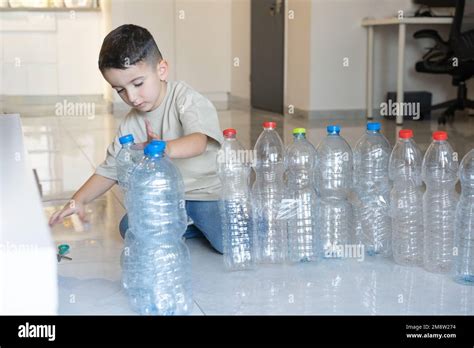 Child build a tower from recycled plastic bottles. Idea uses of old plastic bottles Stock Photo ...