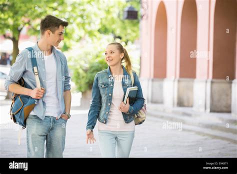 Young college friends talking while walking at campus Stock Photo - Alamy