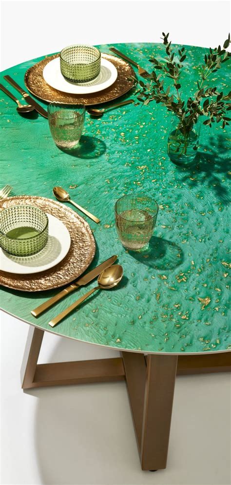 the table is set with gold and green place settings