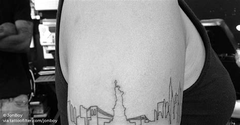 New York skyline tattoo on the left upper arm.