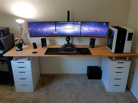a computer desk with two monitors on top of it and drawers under the desk below