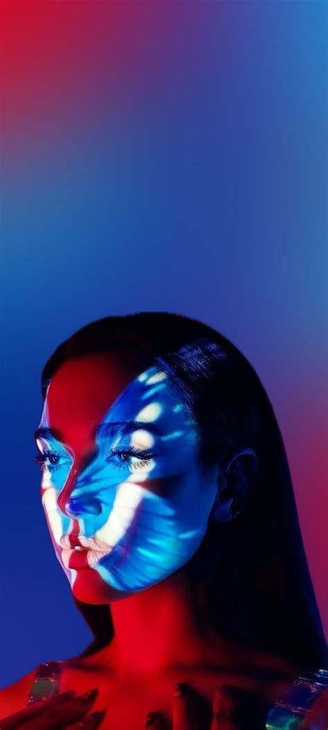 a woman with blue and red face paint on her body is looking at the camera