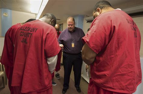 An inmate at the Allegheny County Jail prays over a photo of his family.