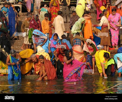 People bathing and praying on the ghats of the river Ganges in Varanasi ...