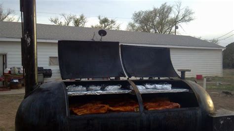 two bbq grills sitting in front of a house