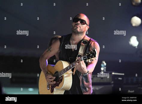 Lenny Kravitz shows off his tattoos in a sleeveless leather vest as he ...