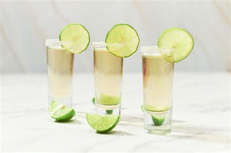 Premium Photo | Three traditional tequila shots with lime and salt ...