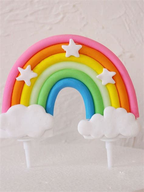 a rainbow cake topper with stars and clouds on it