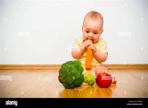 Estilo de vida saludable. Bebé Comiendo frutas y hortalizas - interiores en casa Fotografía de ...