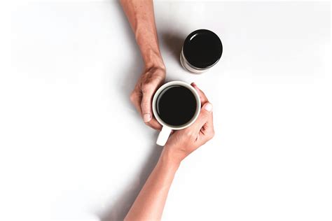Two Person's Hand Holding White Mug Filled With Coffee · Free Stock Photo