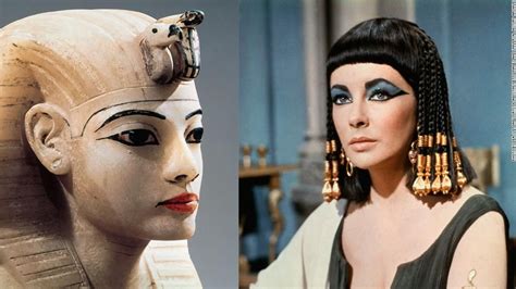 an egyptian woman wearing gold earrings next to a statue of the queen nefere