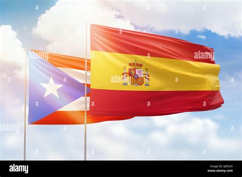 Sunny blue sky and flags of spain and puerto rico Stock Photo - Alamy