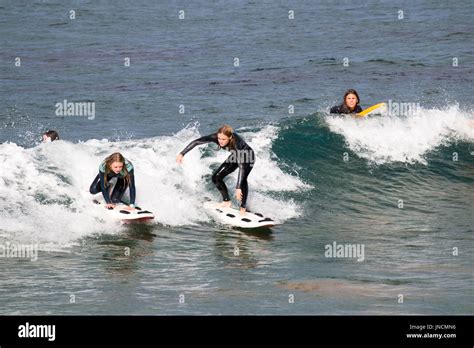 Young Australian women teenagers surfing in the ocean at Avalon beach ...