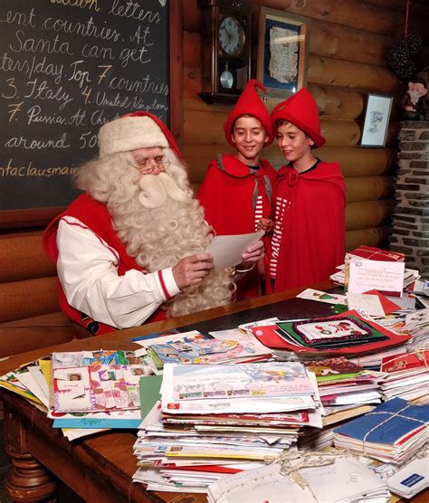 Santa Claus and twin elves in the Santa Claus Main Post Office in Rovaniemi in Lapland Finland ...