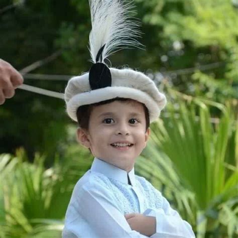 Child wearing a traditional wool Chitrali Topi (hat) with feather - Pakistan. Pakistan Culture ...